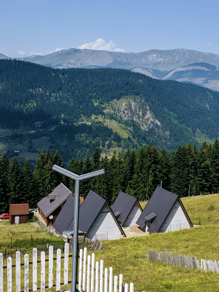 white-and-brown-house-on-green-grass-field-near-green-mountains-during-daytime-eey5ma7nwye